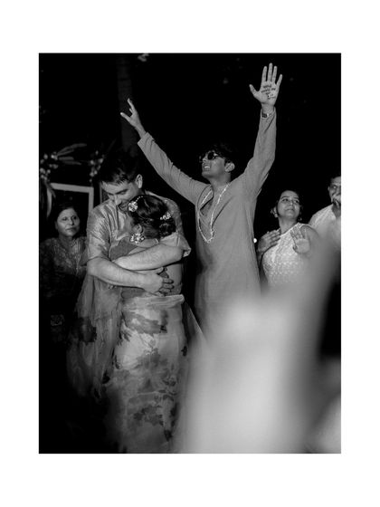 In the middle of the celebration, a quiet embrace. This black and white photo freezes a candid moment of connection between the couple, while the energy of the party continues around them.