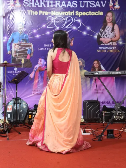 A back profile shot on the stage of "Shakti Raas Utsav," showcasing my traditional lehenga for the event.
