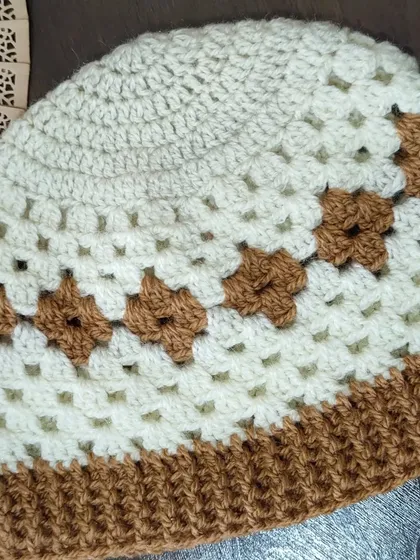 A side view of the Diamond Granny hat, showing the simple yet effective brown and cream color combination. This is a fun twist on a traditional beanie.