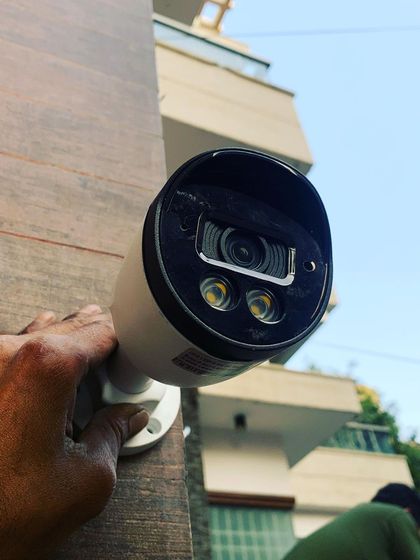 A close-up of an outdoor bullet camera with powerful IR LEDs for clear night vision, being installed by our technician.
