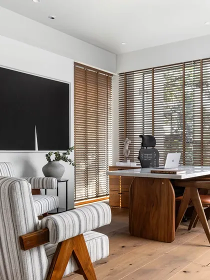 We designed this Director's Cabin as a sanctuary for focus and inspiration. The space balances authority and comfort, using a palette of warm oak, crisp whites, and bold, custom-made black artwork. Natural light filters through wooden blinds, creating a calm atmosphere that is both professional and deeply personal.