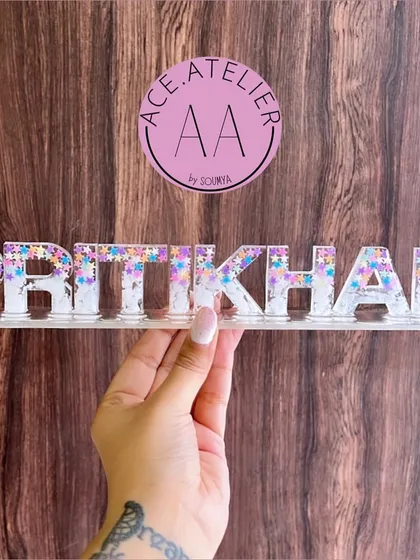 This 'Pritikhan' name stand features a mix of white and sparkling star glitter, giving it a magical and dreamy look. It's perfect for adding a touch of sparkle to any space.