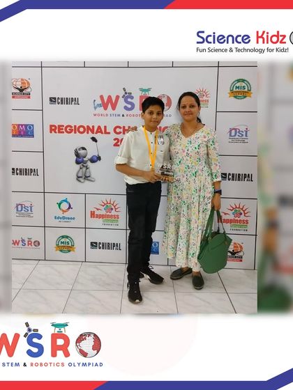 A proud moment for our student and his mother at the WSRO Regional Championship. He is holding his trophy after a successful run in the Young Scientist category.