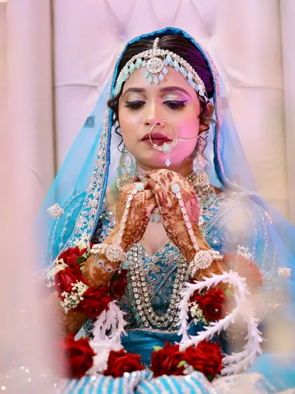 A close-up of the intricate details. The eye makeup, jewellery, and floral garlands all come together beautifully.