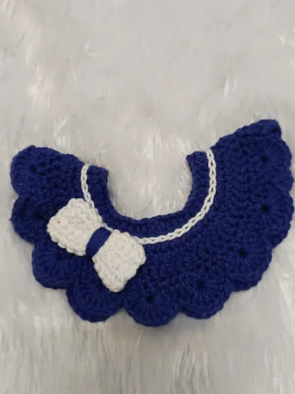 A close-up of the royal blue scalloped collar. The white trim along the neckline and the neatly crafted bow make this a polished and adorable accessory for any child.