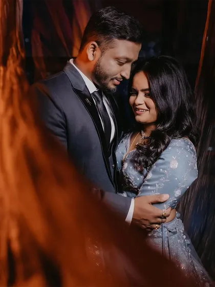 A warm, intimate portrait of a couple at their reception, with fairy lights creating a beautiful, glowing foreground.