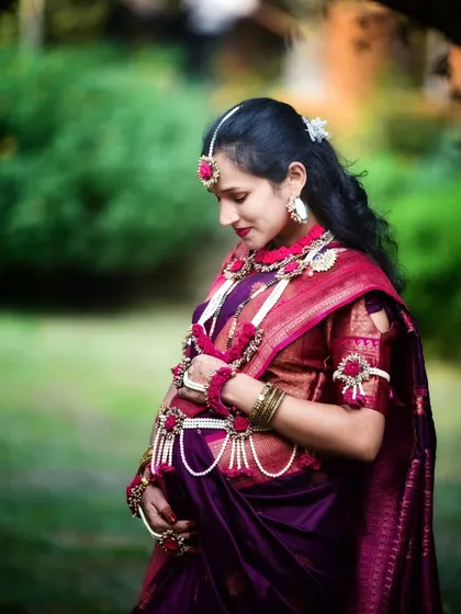 A beautiful outdoor portrait celebrating Maharashtrian traditions. The soft natural light highlights the intricate details of the saree and the delicate floral jewellery, creating a truly timeless image.