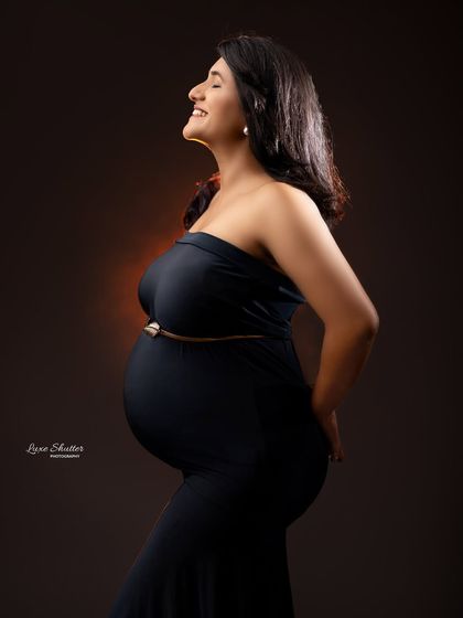 The pure joy of pregnancy captured in a single moment. This side profile shot with a radiant smile is simple, timeless, and full of happiness.