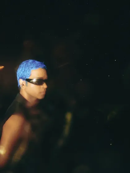 A moody, atmospheric shot from the 'Eclipse' editorial. The vibrant blue hair I created provides a striking point of contrast in the low-light photo.