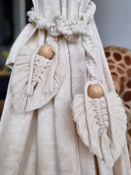 A closer look at our natural cotton macrame curtain tie-backs. The wooden bead and leaf design adds an organic and stylish touch to your curtains.