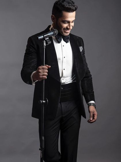 A classic black velvet tuxedo, complete with a pleated shirt and cummerbund. This is the epitome of black-tie elegance, tailored for a flawless fit.