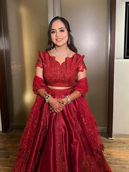 The bride's complete Sangeet look. The bold red outfit is balanced with classic smokey eye makeup and a neutral lip for a sophisticated finish.