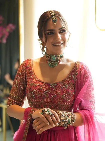 The complete look from our collaboration with Purab Paschim and Ridhi Mehra. The model wears a stunning fuchsia lehenga with a full set of eclectic, multi-gem jewelry.