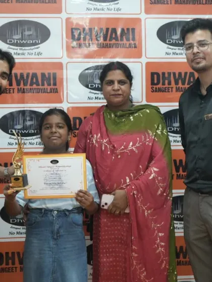 A student with prev mother and teacher, celebrating her award.