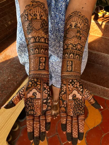 A stunning engagement mehendi with full coverage. The design is packed with traditional elements like peacocks and architectural domes, perfect for a grand celebration.