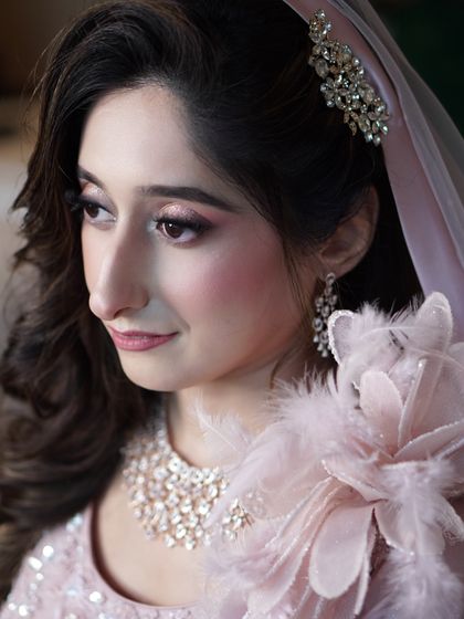 Capturing the soft elegance of an engagement look. The gentle pink tones on the eyes and cheeks, paired with a delicate hair accessory, create a romantic and modern bridal style that is simply stunning.