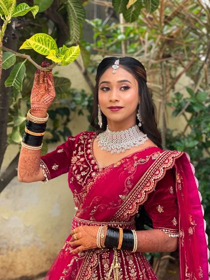 Pallavi posing for a photo at her reception. This shot shows how the makeup and hairstyle come together to create a polished and photogenic look.