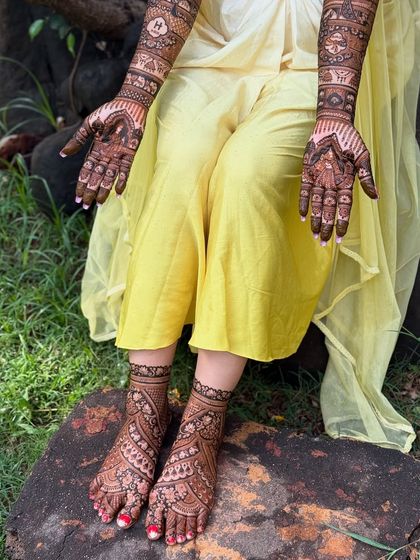 A full view of the bride's hands and feet, showcasing the stunning, coordinated mehendi art.
