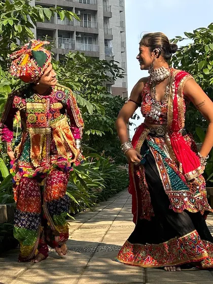 A dynamic pose from a dancing duo. His colorful dhoti pants and Kedia are perfectly in sync with her vibrant red and black chaniya choli.