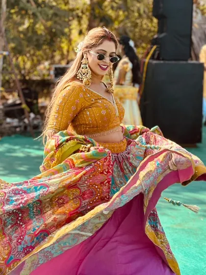 Your Mehendi or Sangeet look should be full of life. This vibrant, multi-colored lehenga with a mustard yellow blouse is designed for exactly that, allowing you to dance and celebrate in style. The large chaandbali earrings complete the festive look.