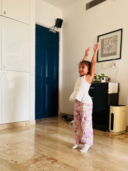 Reaching for the sky. Even the simplest stretches are done with intention to improve posture and body awareness.