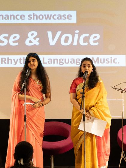 Two poets performing a collaborative piece in beautiful sarees. Our workshops encourage creative collaboration among participants.