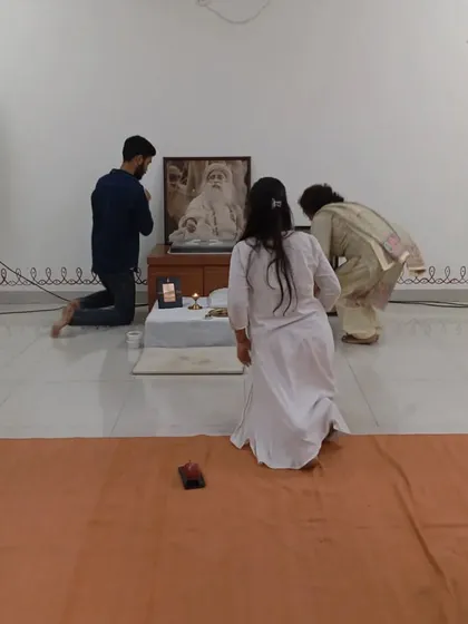 Seekers bowing in gratitude before the Sadhguru Sannidhi after a puja. The feeling of grace in the room is palpable, a shared experience for the entire spiritual family.