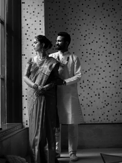 A timeless black and white portrait of a couple by the window. This artistic shot highlights the emotion and connection, proving that love is beautiful in every shade.