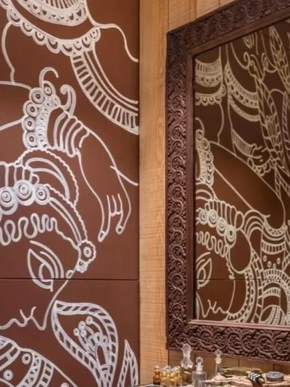 A detail of the Pichwai-inspired mural, showcasing the delicate hand-painted figures and motifs reflected in a mirror.