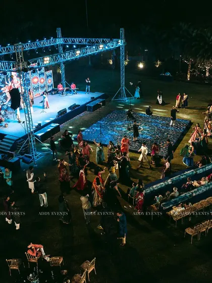 A grand outdoor sangeet in full swing, showcasing a massive stage, multiple LED screens, and an enthralled audience. This bird's-eye view captures the scale of the events we produce, combining world-class entertainment with large-format technical execution for an unforgettable night.