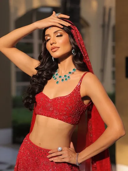 A sun-kissed shot that highlights the vibrant red color and the sparkling details of the outfit.
