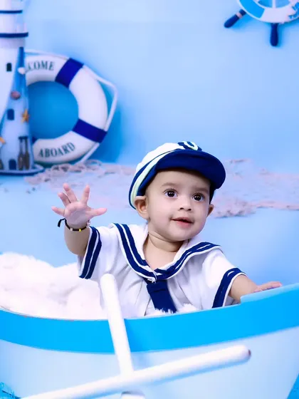 A happy little sailor waves from his boat in our nautical-themed studio.