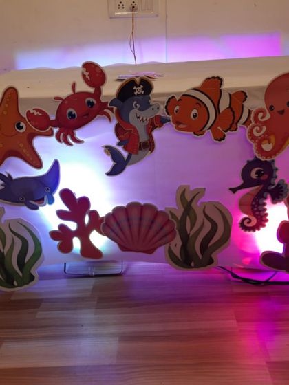 The details matter in a themed party. This under-the-sea setup included a variety of illuminated sea creature cutouts like crabs, starfish, and clownfish, creating a vibrant and colorful underwater scene.