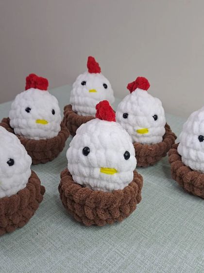 A group of plush chickens sitting in their little nests.