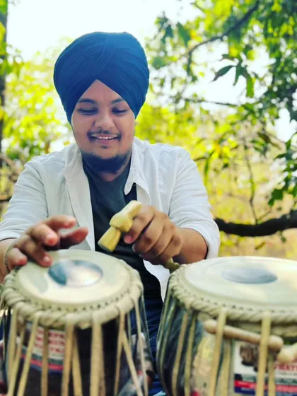 Tuning my tabla in nature. The right sound is everything, and I take great care to ensure my instrument is perfectly tuned before every performance.