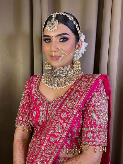 This bride is an absolute doll. Her ethereal look in a pink lehenga is all about soft, romantic details, from the makeup to the floral hair accessories.