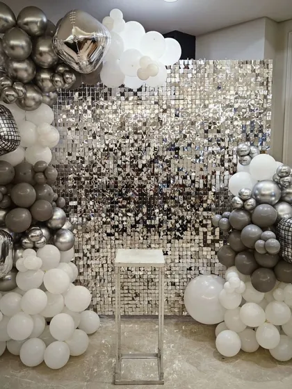For a modern and glamorous party, we offer this stunning silver shimmer wall. Paired with organic balloon columns in white, grey, and chrome, and accented with disco ball foil balloons, this backdrop is guaranteed to make your bachelorette or birthday party photos pop.