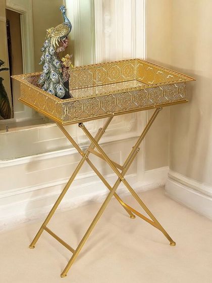 This festive side table combines utility with glamour. The rectangular tray top has intricate detailing and sits on a foldable, cross-legged stainless steel base, making it a stylish and practical addition for entertaining.