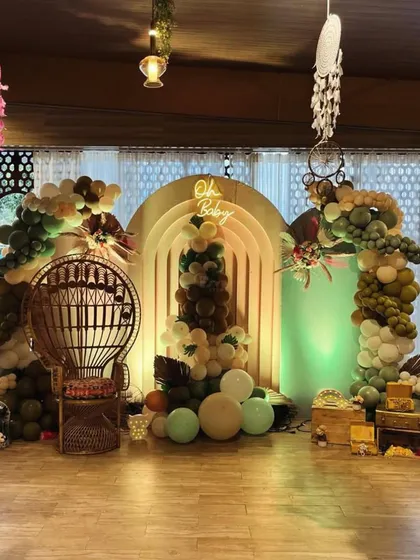 Our signature boho baby shower setup. We combined earthy-toned organic balloon arches with pampas grass and a custom "Oh Baby" neon sign to create a warm, inviting photo zone. The wicker peacock throne makes the mom-to-be the true center of attention.