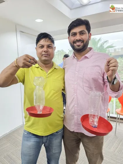 Two proud creators with their finished bird feeders. These can be hung in balconies or gardens to provide food and water for birds.