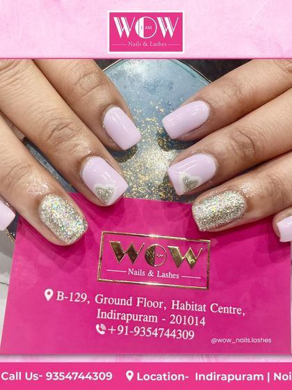 A sweet and simple manicure featuring a soft pink polish with silver glitter and heart accents. This look is perfect for showing off healthy, well-cared-for natural nails.