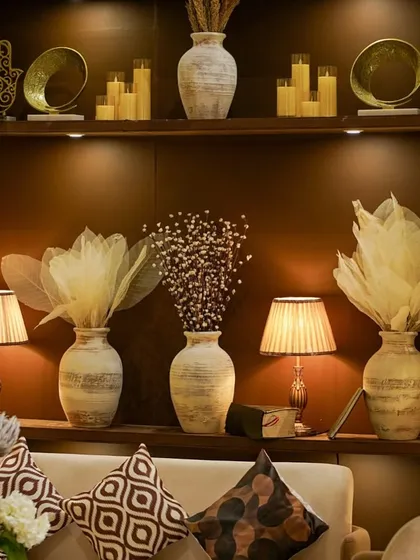 The beautifully styled shelves behind the lounge seating, filled with curated objects, candles, and floral arrangements to create a rich and interesting backdrop.