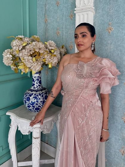 A close-up of the ruffled shoulder detail on this pink draped saree. It's a fashionable and unique design element.