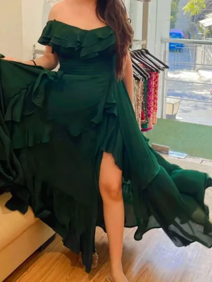 Make an entrance with this stunning emerald green off-shoulder gown. Made from flowing crepe fabric with a thigh-high slit and cascading ruffles, this custom dress is designed for maximum impact at any party or event.