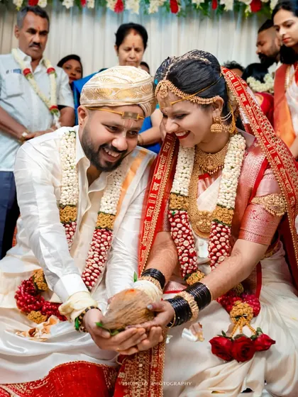 A moment of shared joy as the couple holds a coconut, a symbol of prosperity, during their wedding ceremony.