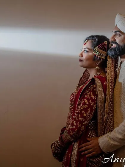 A dramatic portrait of a couple in traditional Muslim wedding attire, looking towards a single light source. The creative use of shadow and light creates a powerful, cinematic feel.
