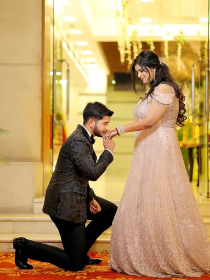 A romantic gesture as the groom kisses his fiancée's hand. This classic pose is always a beautiful addition to an engagement album.