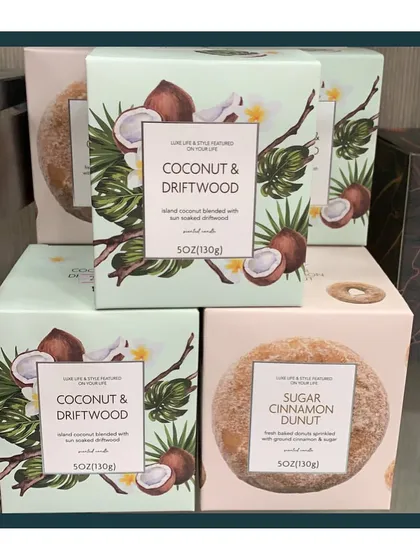 I source candles with unique and soothing scents you've never smelled before. Pictured here are the beautifully packaged Coconut & Driftwood and Sugar Cinnamon Donut candles.