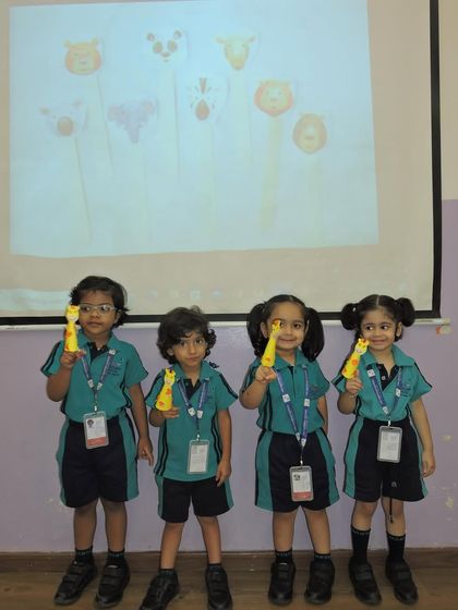 A group of students shows off the animal-themed puppets they made. Crafting is a wonderful way to develop fine motor skills and creativity.