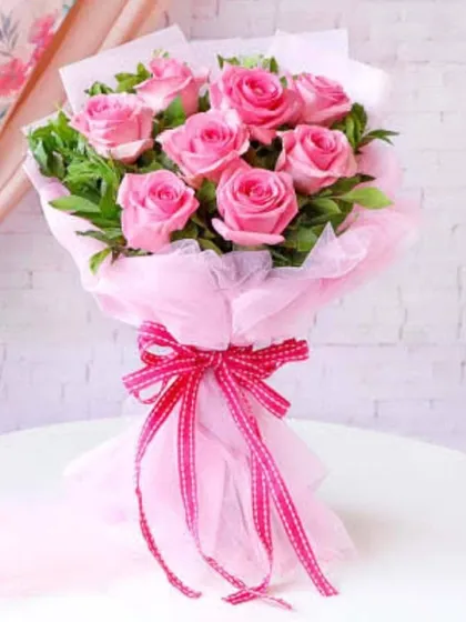 A classic bouquet of eight pink roses, beautifully arranged and tied with a pink ribbon. This is a perfect example of a clean and elegant floral gift.